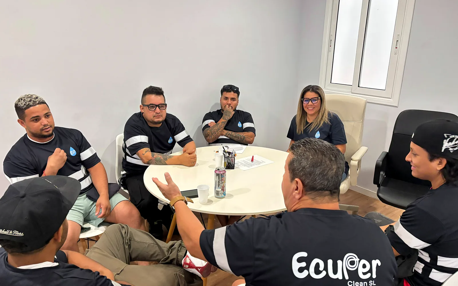 Parte del equipo de Ecuper Clean reunido en nuestras instalaciones con equipos de pértiga y sistemas de aspiración avanzada en un aparcamiento subterráneo de gran capacidad. El entorno es industrial, con tuberías expuestas y estructuras de hormigón, iluminado de forma técnica y nítida. El estilo visual es profesional, reflejando maestría técnica y precisión.