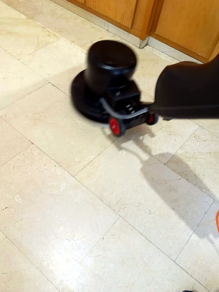 Máquina rotativa sobre pavimento de mármol de un portal